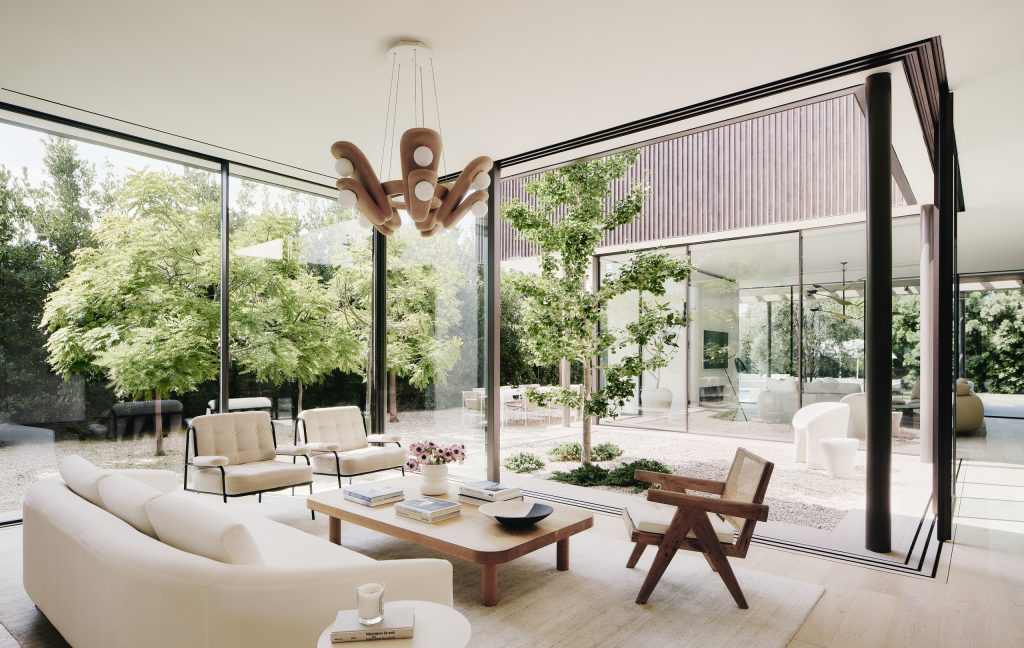 Moreno Residence living room in Brentwood with floor-to-ceiling glass walls opening onto a landscaped central courtyard.