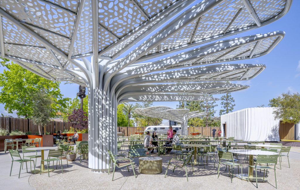 Sculptural perforated shade canopies shelter outdoor seating and gathering areas at the SNAP Campus.