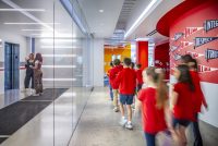 Students in red uniforms walk through a colorful Village School hallway in Santa Monica.