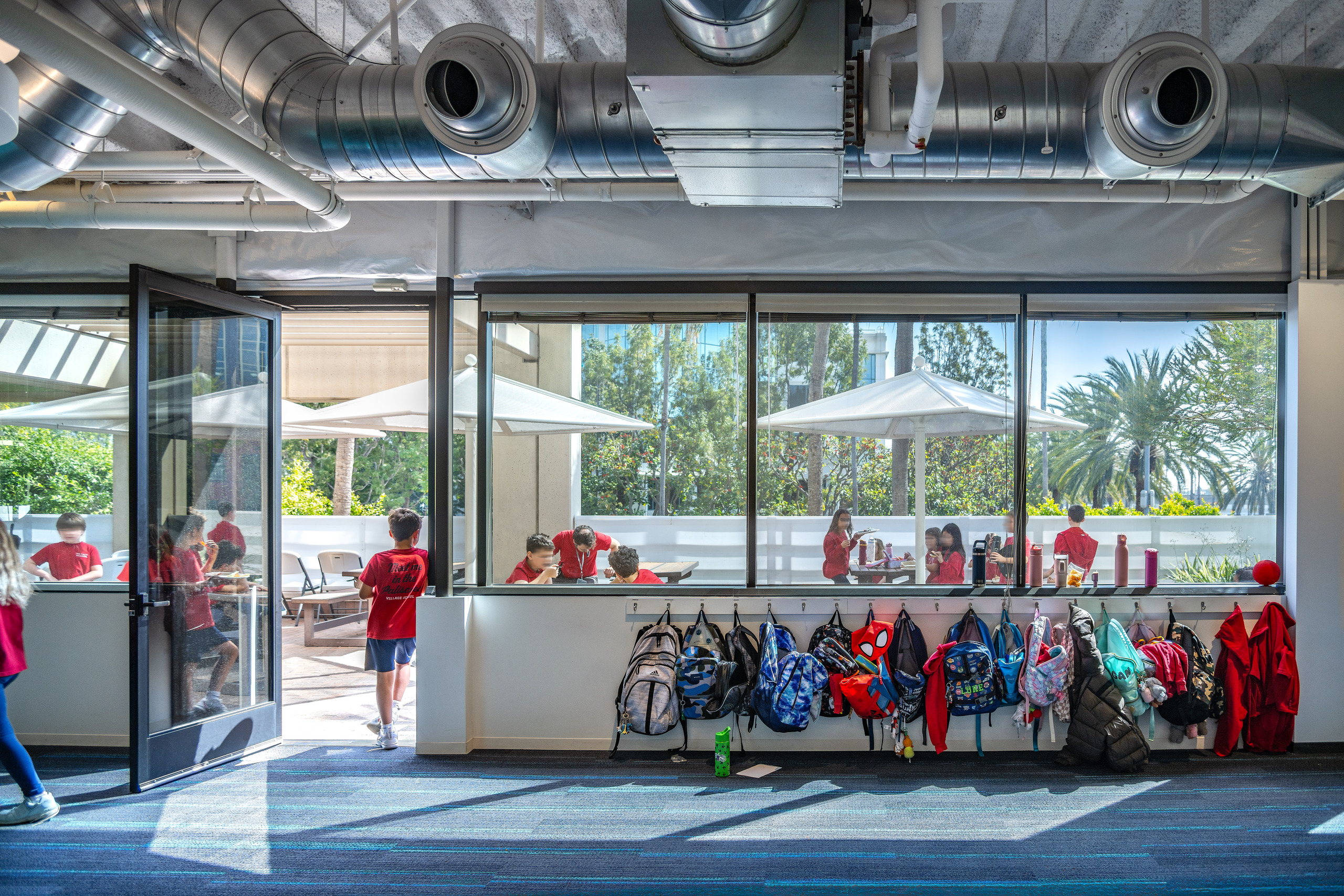 Students eating outdoors on a sunlit terrace at Village School in Santa Monica.