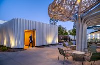 Evening view of SNAP Campus Park with illuminated shade canopies and outdoor gathering spaces.