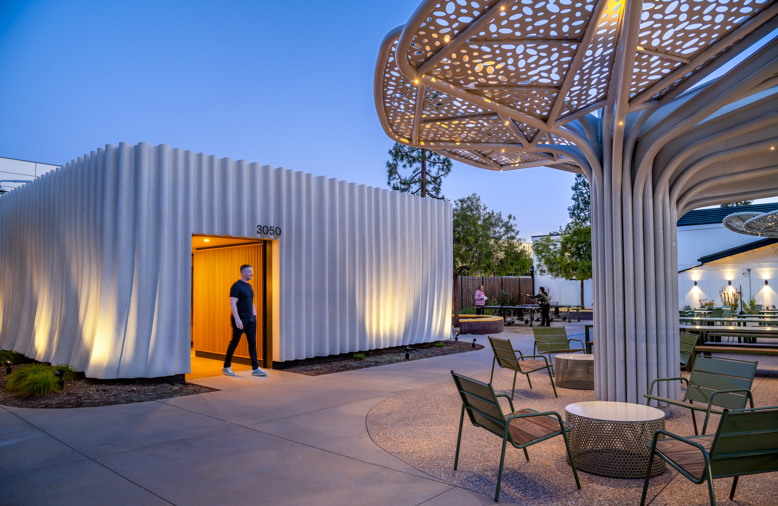 Evening view of SNAP Campus Park with illuminated shade canopies and outdoor gathering spaces.