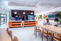 Employee café and collaborative workspace at SNAP Campus with communal tables and integrated amenities.