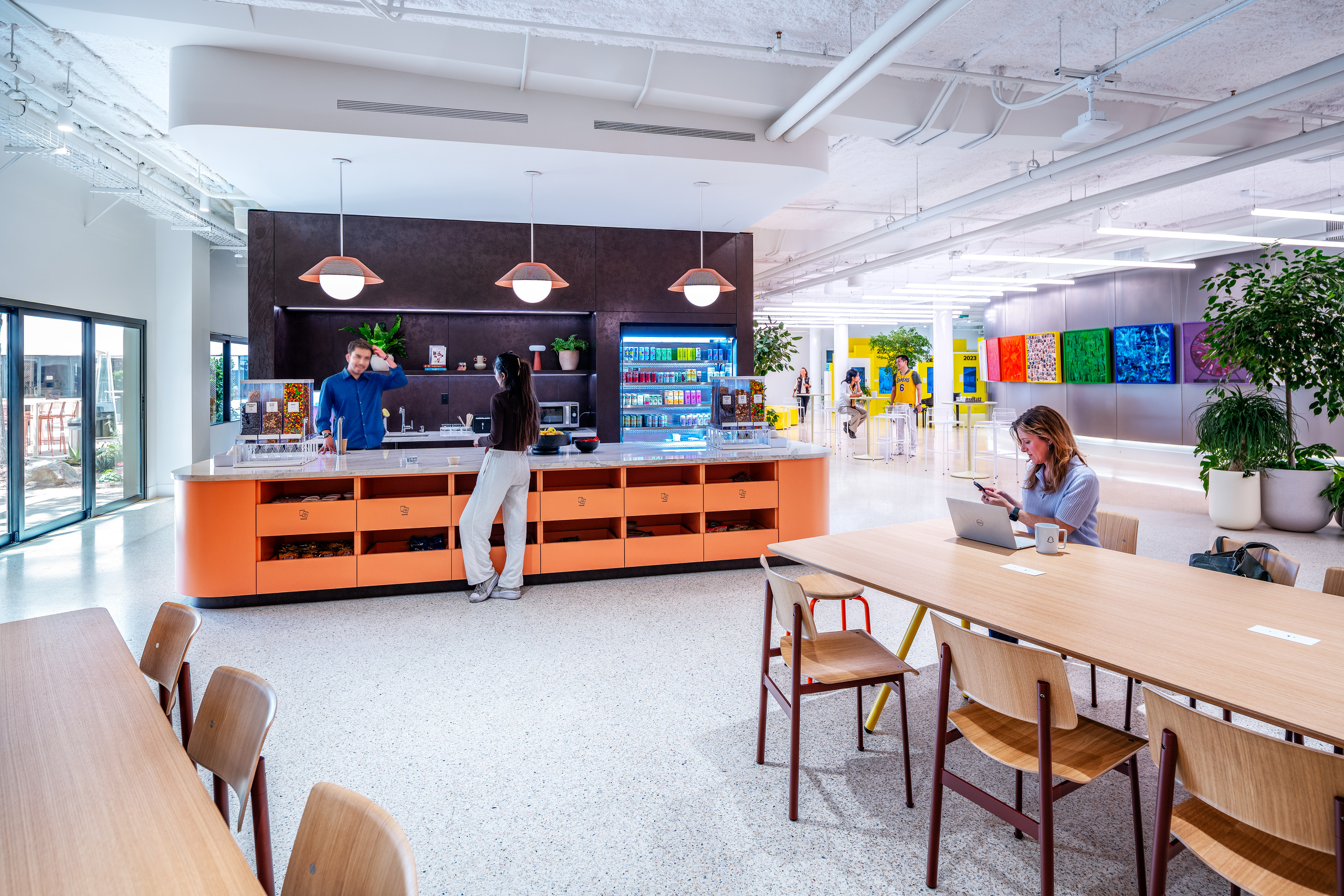 Employee café and collaborative workspace at SNAP Campus with communal tables and integrated amenities.
