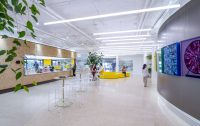 Main Street at SNAP Campus featuring the employee café, gallery wall, collaborative seating, and hospitality-inspired workplace design by OFFICEUNTITLED.