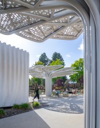 View of the amenity building and custom shade canopies creating outdoor gathering spaces at SNAP Campus Park.
