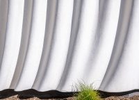 Detail of the textured mica-infused plaster façade at the SNAP Campus amenity building designed by OFFICEUNTITLED.